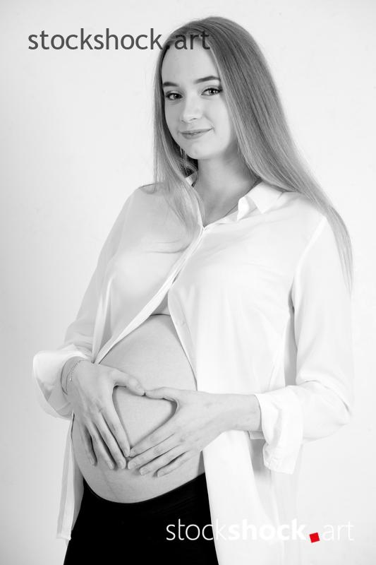 A happy future mother with a heart on her pregnancy belly