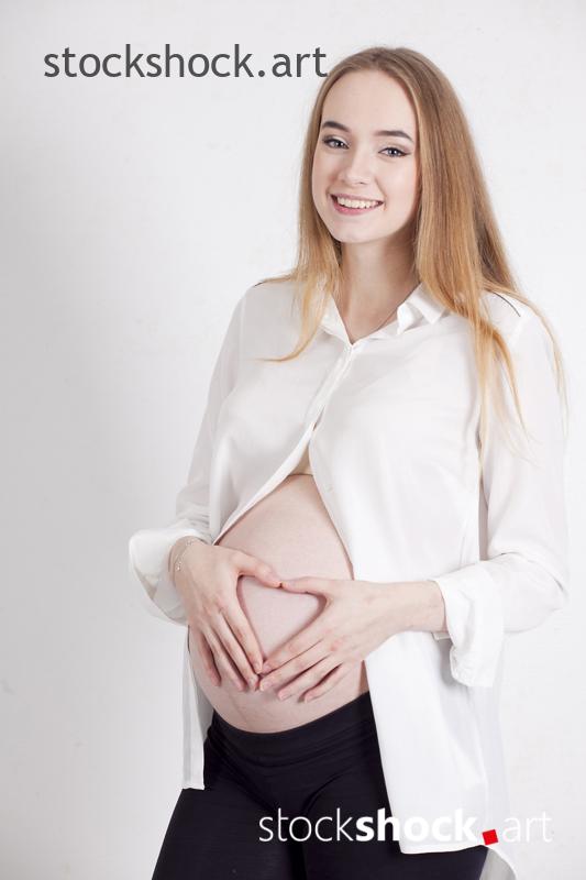 A happy future mother with a heart on her pregnancy belly - stock image