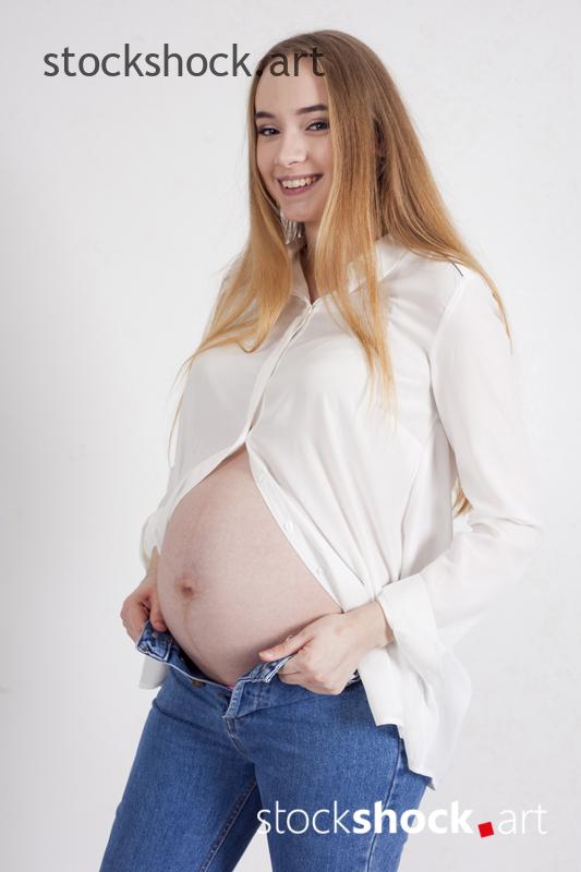 Young pregnant woman in a white T-shirt and jeans, stock image