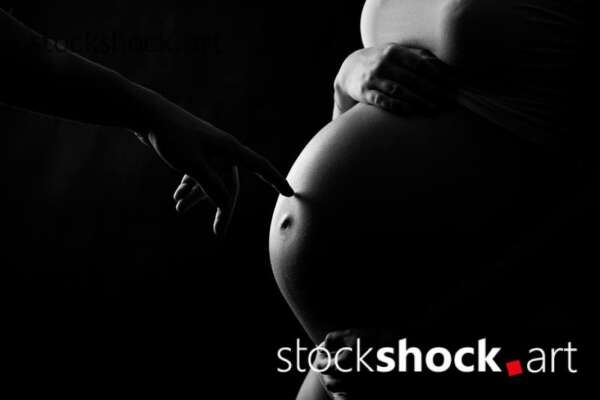 Mother and father's hands on the pregnant belly