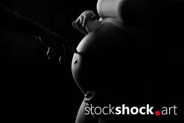 Mother and father's hands on the pregnant belly