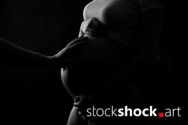 Father hand on the pregnant belly