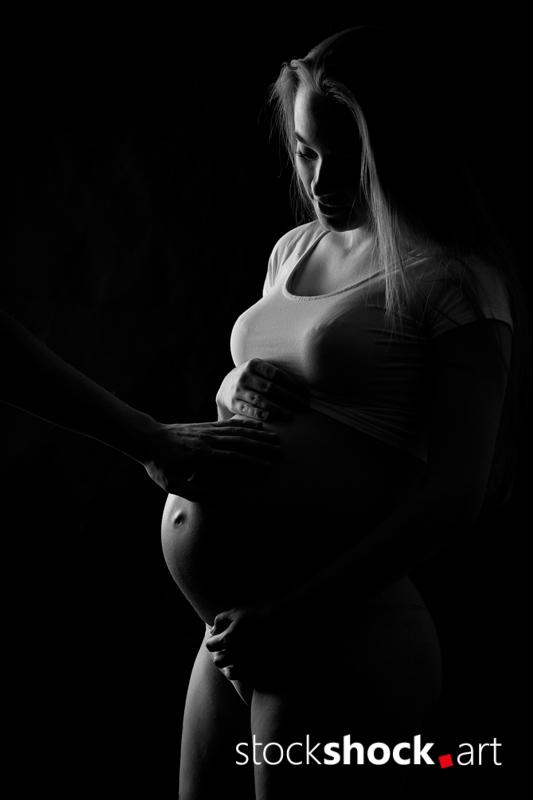 Mother and father's hands on the pregnant belly