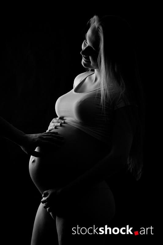 Mother and father's hands on the pregnant belly