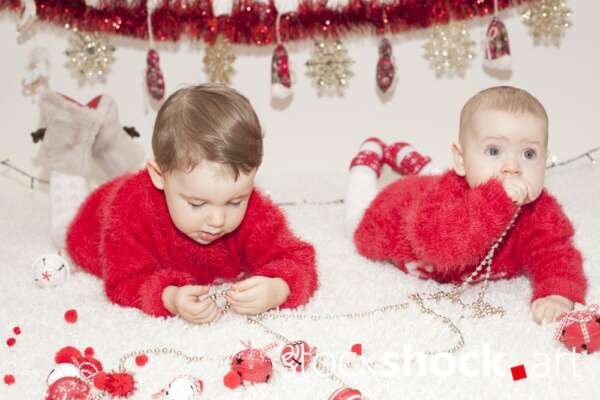 Two little girls play with Christmas decorations