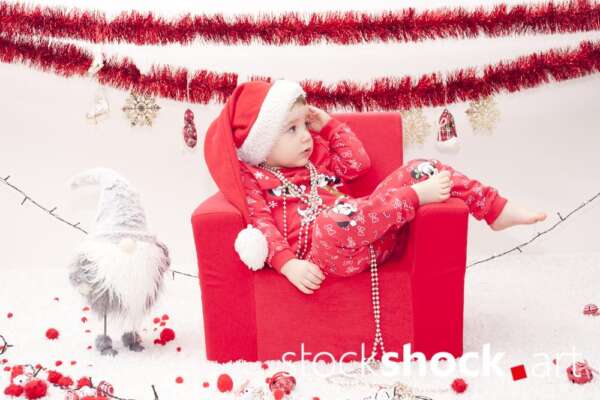A child in a Santa Claus costume in an armchair. Christmas holidays - stockshock image