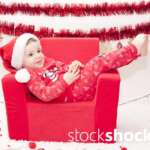 A child in a Santa Claus costume in an armchair. Christmas holidays - stockshock image