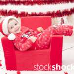 A child in a Santa Claus costume in an armchair. Christmas holidays - stockshock image