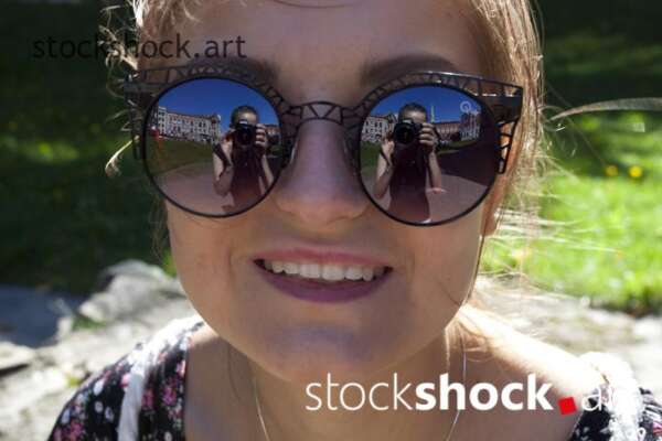Young girl with glasses. Reflection of the image in the glasses