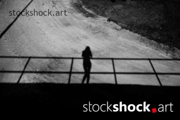 Shadow of woman on bridge, black and white - stock image