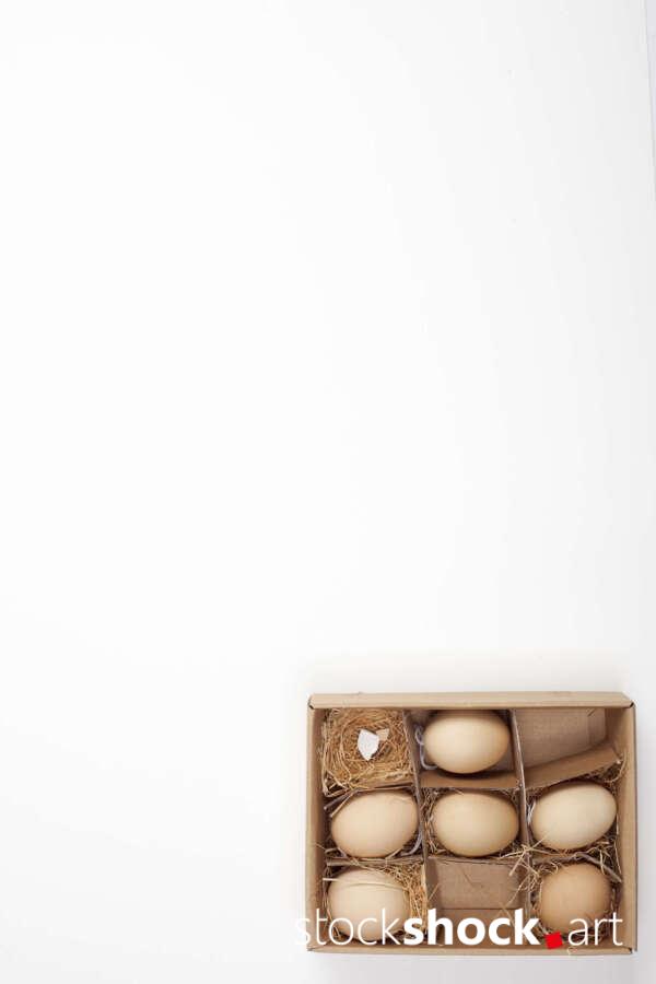 Easter. Eggs in a carton with a straw lining on a white background