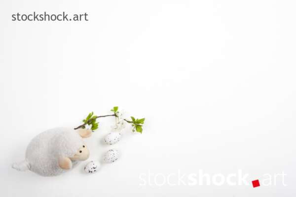 Easter lamb with eggs and a branch of blooming cherry on a white background