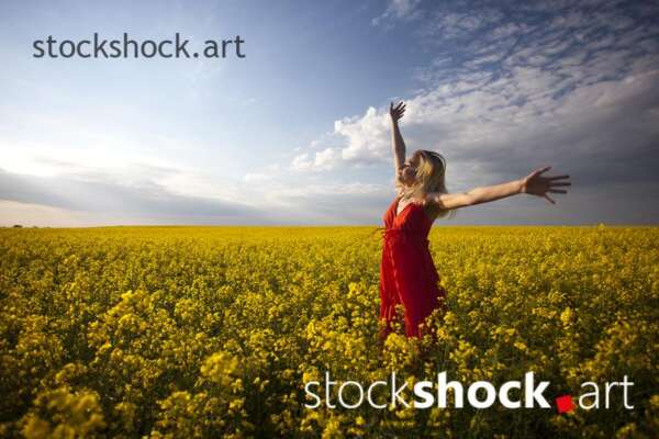 girl in a red dress in yellow rapeseed