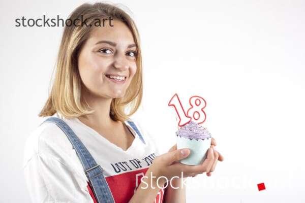 18 birthday, girl with cookie and birthday candles - stock image