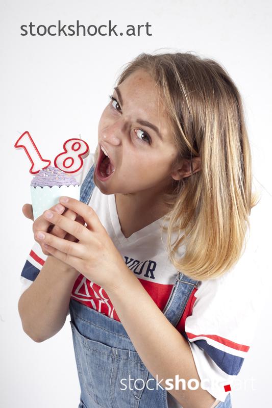 18 birthday, girl on white background with cookie and birthday candles