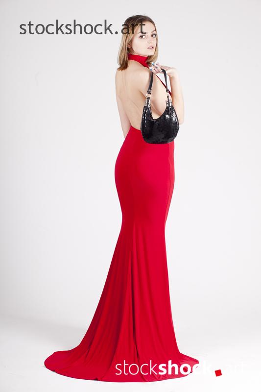 A girl in a red dress with a bag in her hand - stock image