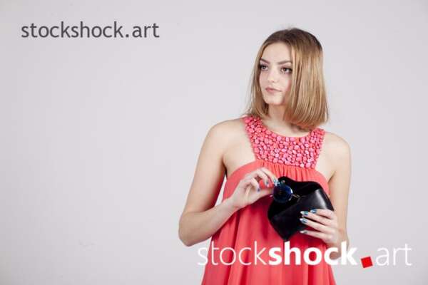 A girl in a red dress with a bag in her hand - stock image