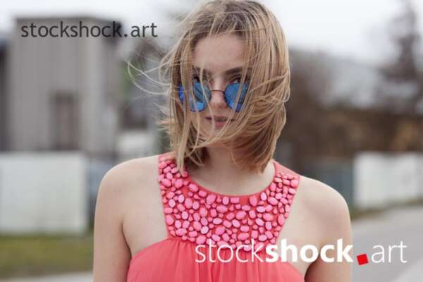 Girl in sunglasses in an orange dress, stock image