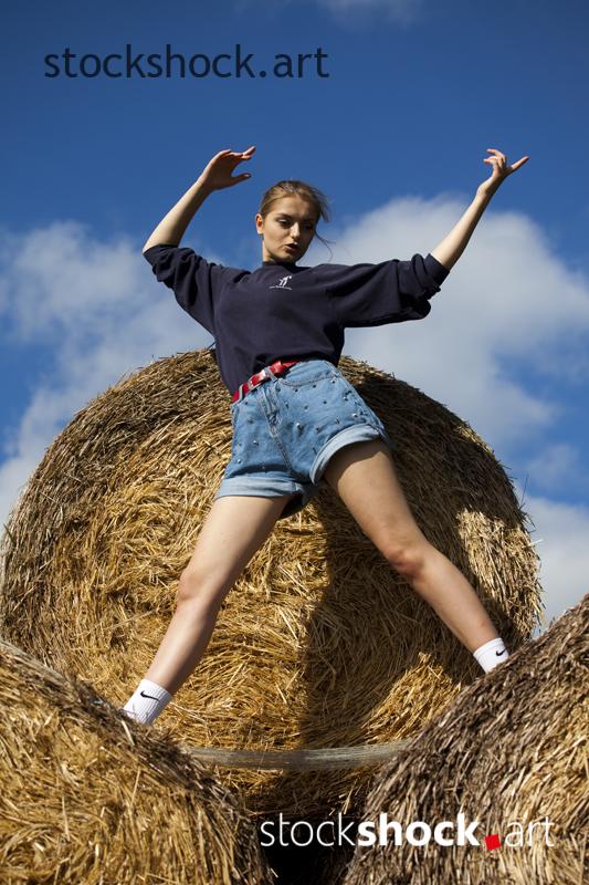 Woman on straw bales - stock image