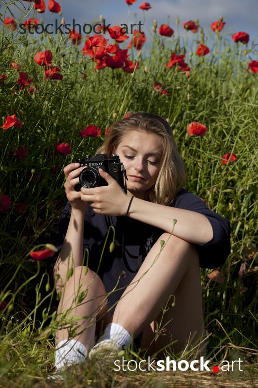 Woman with a Camera, red poppies - stock image