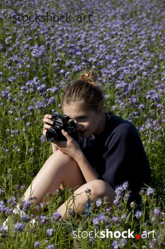 Woman with camera in flowers
