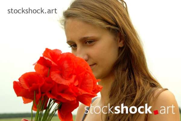 Beautiful girl with a bouquet of field poppies