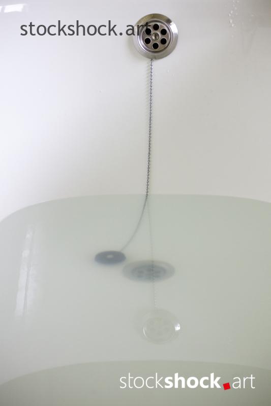 A stopper on a chain in a bathtub with water - stock imageÂ