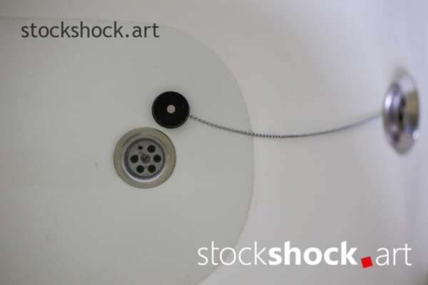 A stopper on a chain in a bathtub with water