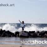Girl on the rocks on the seashore against the background of the wave