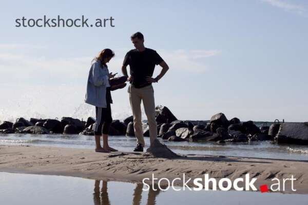 Man and woman on the seashore - stock image
