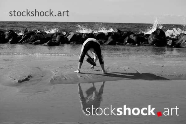 A girl on the seashore writing in the sand