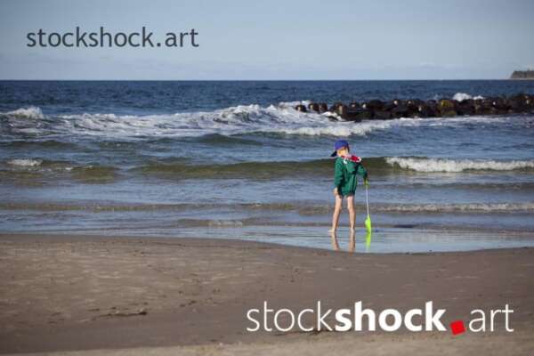 Little boy with a paddle on the seashore