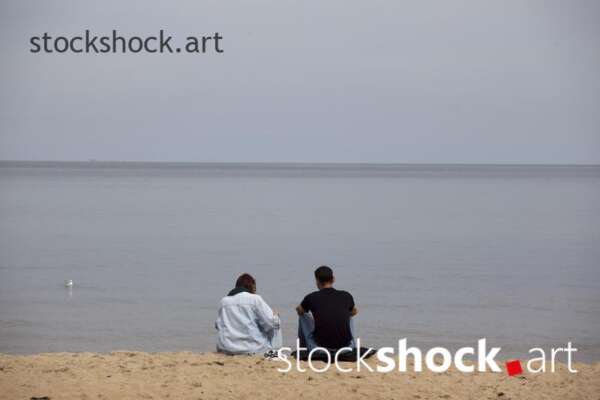 The couple is sitting by the sea - stock image