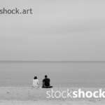The couple is sitting by the sea