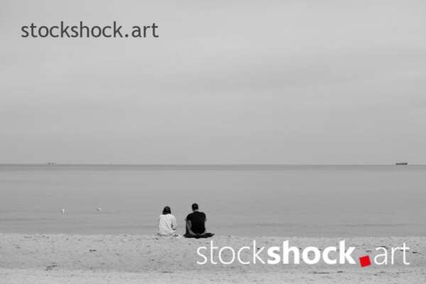 The couple is sitting by the sea