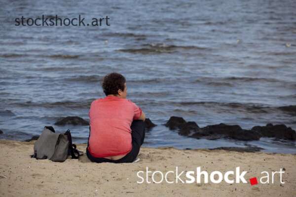 Woman sitting by the sea, stock image