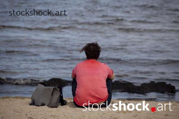 Woman sitting by the sea