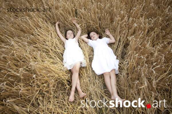 End of harvest two happy sisters sleeping in the field during harvest summer field - stock image, jowita niemczyk, stockshock.art