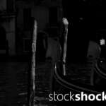 Venetian gondola tied to a wooden pole, black and white photo, stock image, stockshock.art, jowita niemczyk